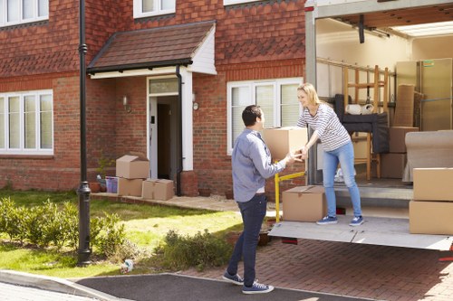 Staff wearing PPE while loading items into a moving van